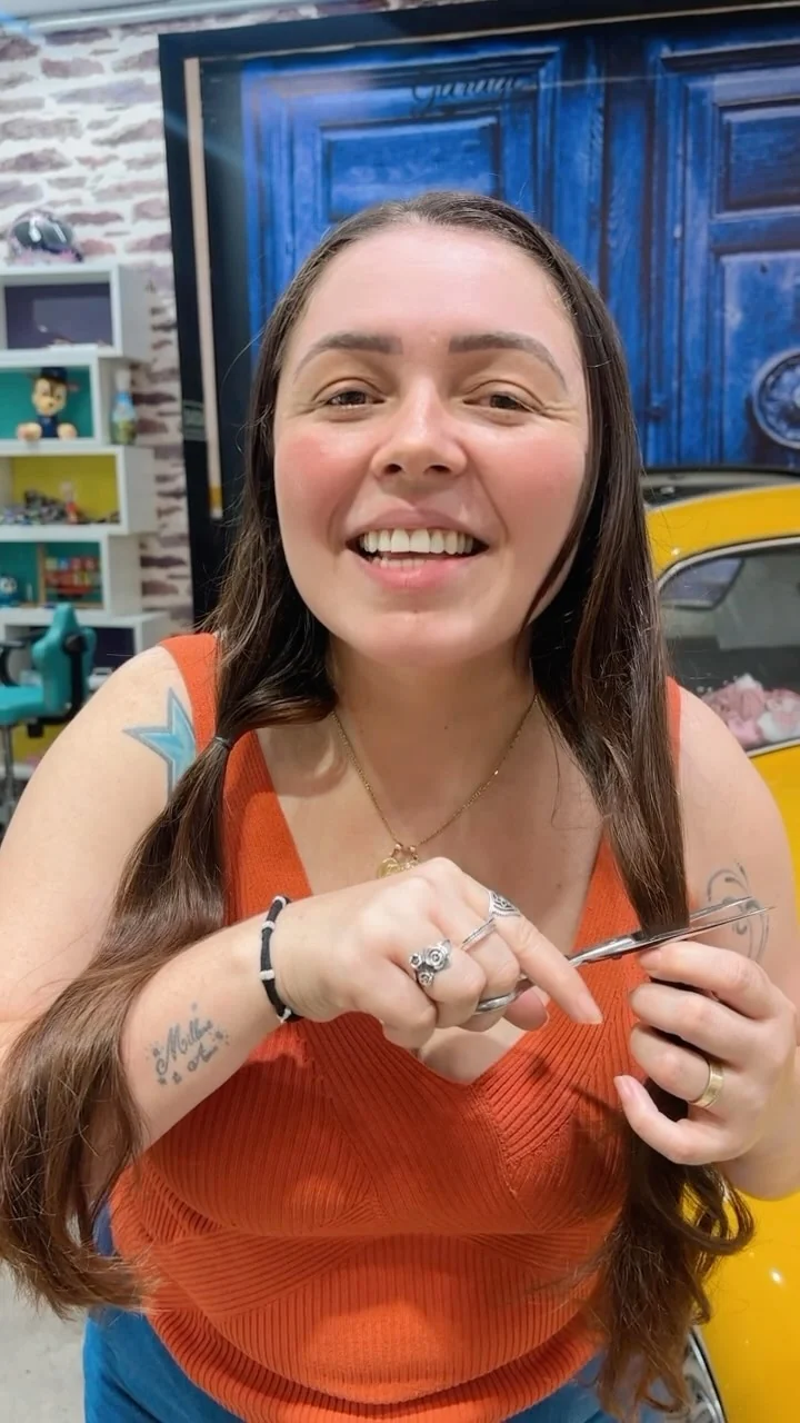 Manuela sorrindo com uma tesoura nas mãos